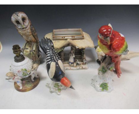 A Sitzendorf parrot; together with another Sitzendorf downy woodpecker, a ceramic cockatoo and barn owl, a continental cerami