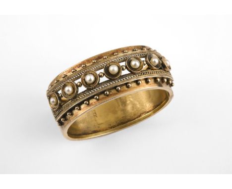 A VICTORIAN GOLD AND PEARL HALF HINGED BANGLE mounted to one side with small pearls within rope and ball embossed decoration,