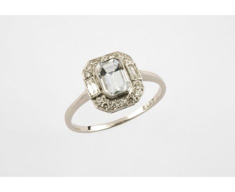 AN AQUAMARINE AND DIAMOND CLUSTER RING the step-cut aquamarine is set within a surround of two baguette-cut and fourteen circ