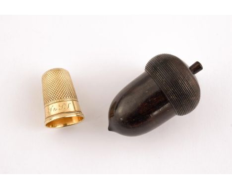 A GOLD THIMBLE with engine turned decoration, inscribed L.M.S. to S.S., in a wooden acorn case