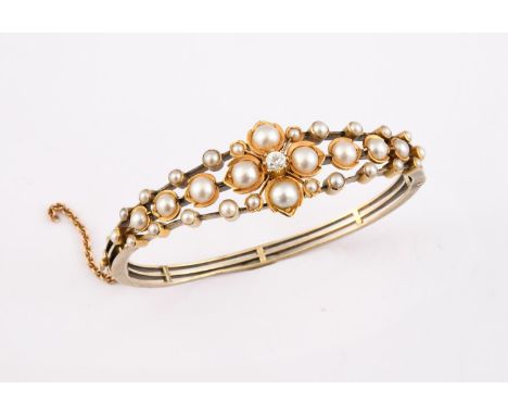 A GOLD, PEARL AND DIAMOND HALF HINGED BANGLE set to one side with a foliate design centred with a circular diamond and set ov