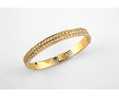 A DIAMOND AND 18CT GOLD HALF HINGED BANGLE set to one side with two rows of circular-cut diamonds, with foliate engraved deco