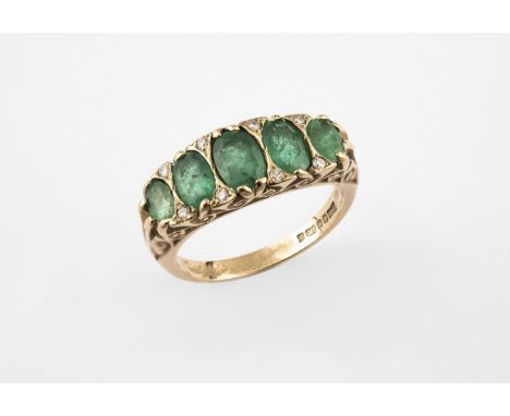 AN EMERALD FIVE STONE RING the five graduated oval-shaped emeralds are set with diamond highlights in yellow gold. Size O 1/2