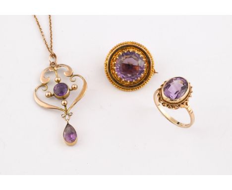 AN AMETHYST AND GOLD PENDANT the yellow gold openwork mounted centred with a circular amethyst and suspending a pear-shaped a