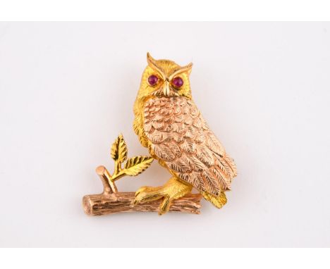 A 9CT TWO COLOUR GOLD OWL BROOCH formed as an owl, realistically formed, sitting on a branch, with ruby cabochon eyes, maker'