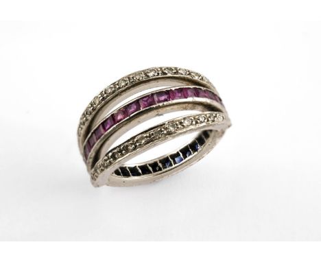 A DIAMOND, RUBY AND SAPPHIRE SWIVEL ETERNITY RING set with calibre-cut rubies and sapphires and circular-cut diamonds. Size L