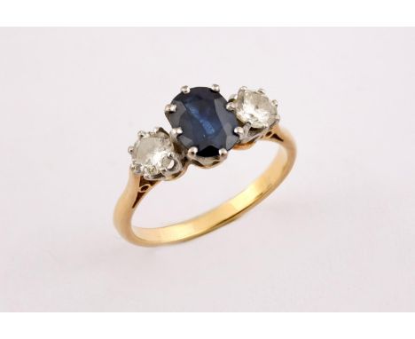 A SAPPHIRE AND DIAMOND THREE STONE RING the oval-shaped sapphire is set with two circular-cut diamonds in yellow gold. Size O