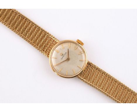 A LADY'S 9CT GOLD WRISTWATCH BY OMEGA the signed circular dial with baton numerals, on an integrated 9ct gold mesh bracelet w