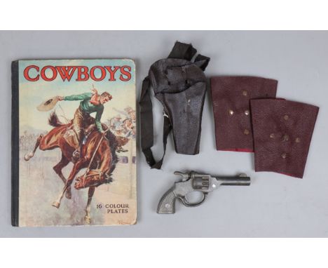 Vintage Dandy cast iron cap gun together with a cowboy book 
