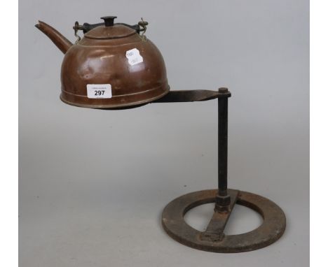 Antique copper kettle on fireside stand 