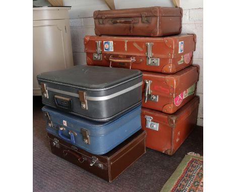 Vintage suitcases, 7 in total, some with travel stickers.