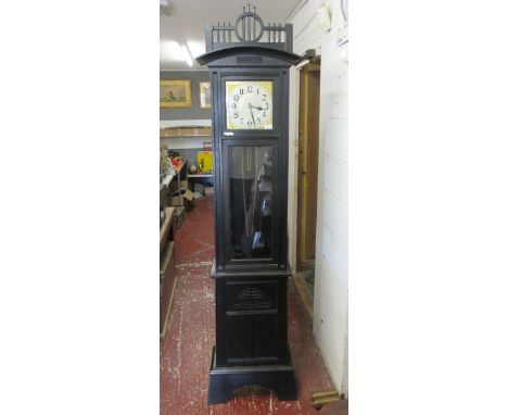 Oak grandfather clock with exposed pendulum and weights. Carved Art Nouveau panel to base. Enamel dial. Top cornice in arts a