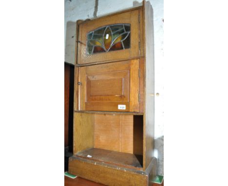 An Arts & Crafts oak narrow cabinet with lead light glazed and panelled door, width 45cm, height 93cm, depth 22cm.