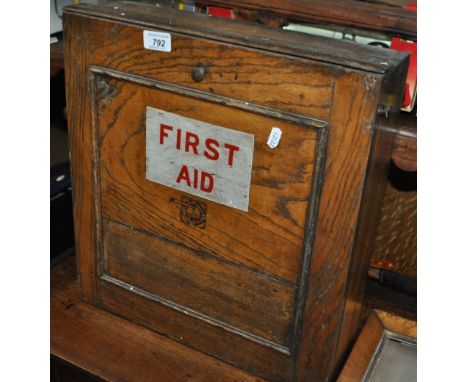 A wall mounted oak First Aid box.