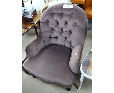 An Edwardian button back upholstered armchair.