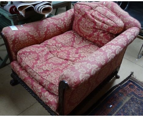A Victorian Waring & Gillow upholstered low armchair, in Chippendale style, with relief carved showwod on lion paw feet, mark