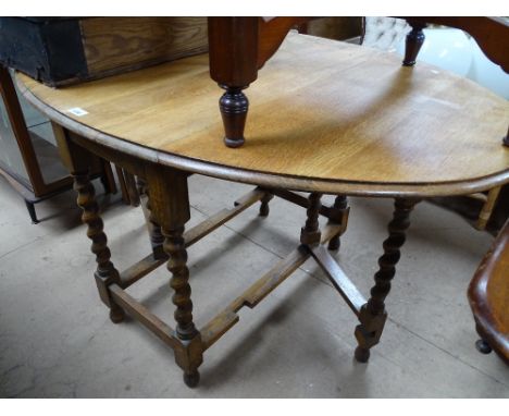 A light oak oval gateleg table with barleytwist legs.