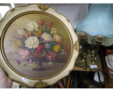 A painting of flowers, a table lamp and a pair of Art Nouveau candlesticks.