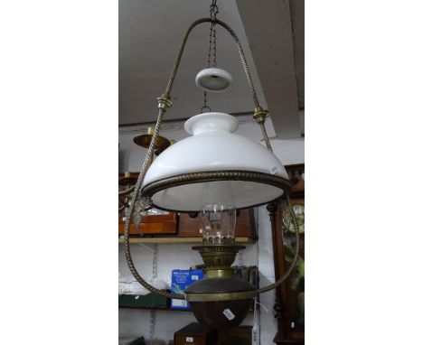 A large Victorian brass framed hanging oil lamp complete with shade and chimney.
