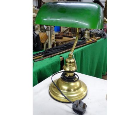 A brass desk lamp with adjustable green glass shade.