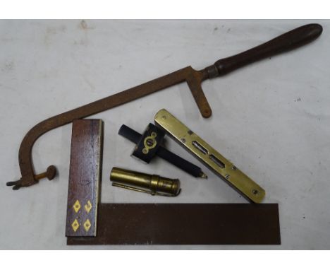 A large early hacksaw, square, spirit level, mortice gauge and a blow pipe.