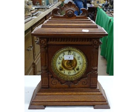 An Antique carved oak cased 2-train mantel clock.