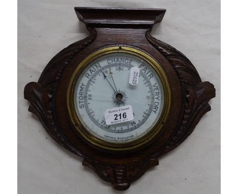 A carved oak framed wall barometer.