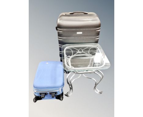 A contemporary glass topped lamp table on metal  base together with IT hard shell luggage case and further cabin case 