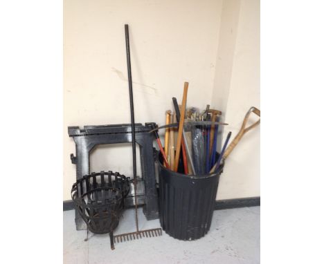 A plastic bin containing assorted garden tools, measuring stick, drain rods, pair of saw horse stands and metal planter 