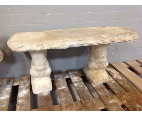 A concrete garden bench on squirell pedestals 