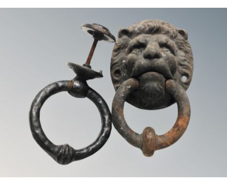 An antique cast iron door knocker modelled as a lion's head and another plain ring 