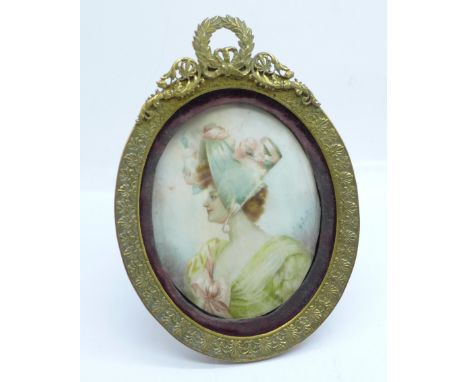 A 19th Century miniature, half portrait watercolour on ivory of a lady wearing a bonnet in an oval gilt metal frame, indistin