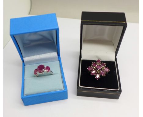 A silver and ruby cluster ring and a silver three stone ruby ring, centre ruby 8mm x 10mm, sizes O and P 