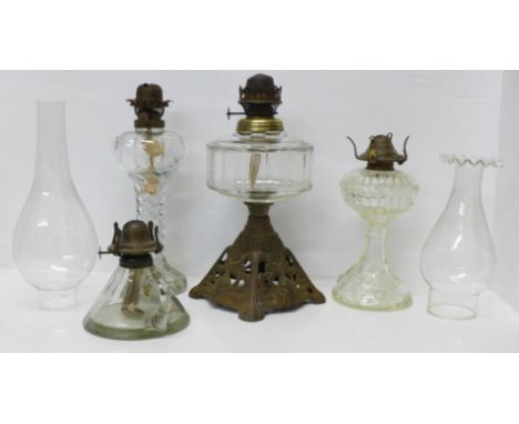 Three glass lamp bases and a glass chamber lamp, chip to the base, and two glass chimneys 