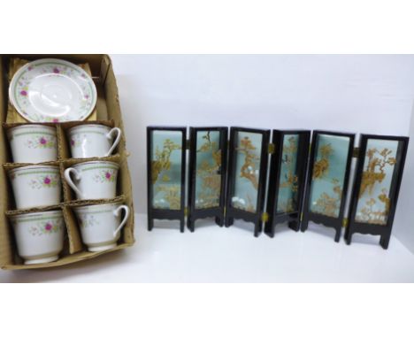 An oriental cork diorama folding table screen and six Chinese cups and saucers 