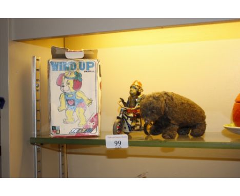 A West German tin plate toy monkey; a wind-up toy bear; and a Chinese jumping dog with original box 