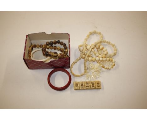 A set of graduated ivory beads; various other carved bone and ivory necklaces; bangles; a cinnabar lacquered bangle etc.