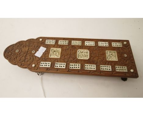 A 19th century carved wooden and inlaid ivory cribbage board on four carved cabriole legs, Indian or Asian