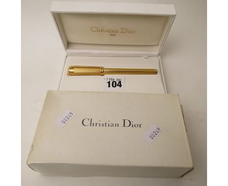 A boxed Christian Dior fountain pen with 18k gold nib, textured gold coloured casing, with spare cartridges, world service an