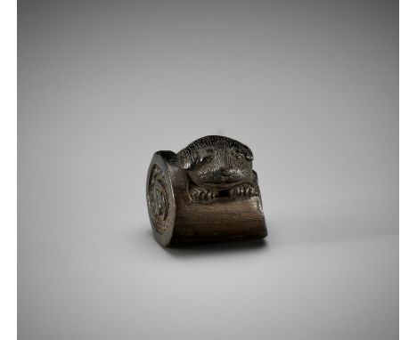 A KUROGAKI WOOD NETSUKE OF A PUPPY IN A ROOF TILEUnsignedJapan, first half of 19th centuryFinely carved as a chubby puppy nes