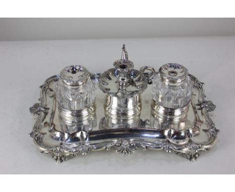 A 19th century silver plated desk stand by Matthew Boulton, with two glass inkwells, of scrolling scalloped form with shell d