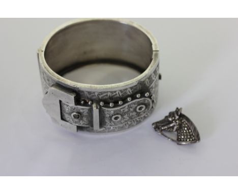 A late Victorian silver bangle, with buckle design, and a silver and marcasite brooch of a horses head