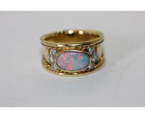 An opal and diamond ring set with an oval cabochon doublet and two trefoils of diamonds 8.4g gross