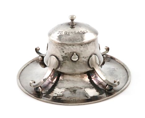 By A. E. Jones, an Edwardian Arts and Crafts silver inkwell, Birmingham 1909, circular capstan form, with spot-hammered decor