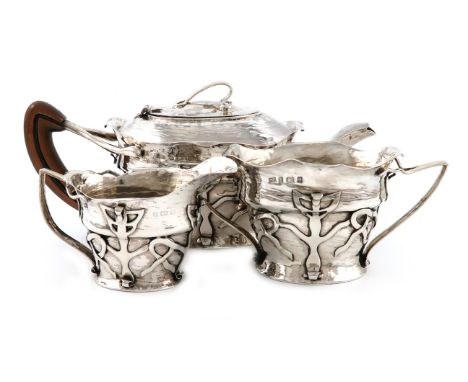 By Charles Harrold and Sons, a three-piece Edwardian Art Nouveau silver tea set, Birmingham 1902, oval form, with intertwined