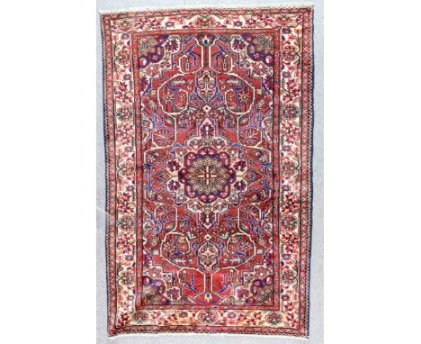 A Bakhtiari Rug, Early 20th Century, woven in colours of navy blue, ivory and wine, with a central stepped flowerhead medalli