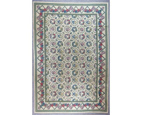 A Modern Needlework Carpet of "Aubusson" Design, woven in colours of fawn, blue, green and rose, with six rows of eleven flor