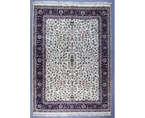 A Kashan Carpet, Early to Mid 20th Century, woven in ivory, fawn and navy blue, the field filled with palmettes and trailing 