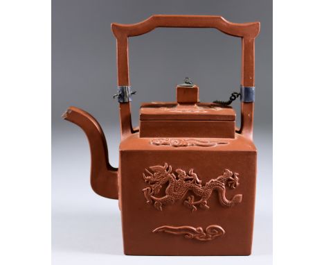 A Chinese Yixing Rectangular Teapot and Cover, 18th Century, with high strap handle, the sides moulded with dragons chasing t
