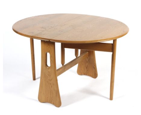 An Ercol gateleg oak dining table. With drop leaf top, on splayed pierced uprights and folding tapering legs, L104cm x D22cm 